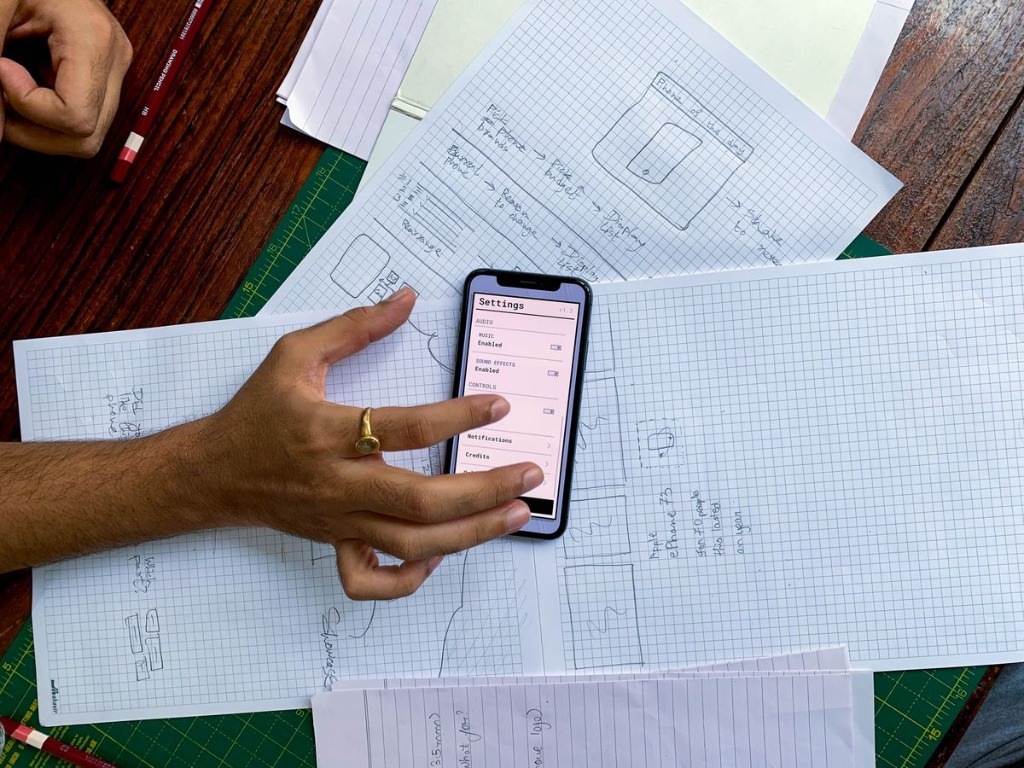 Mobile app wireframe sketches and smartphone prototype