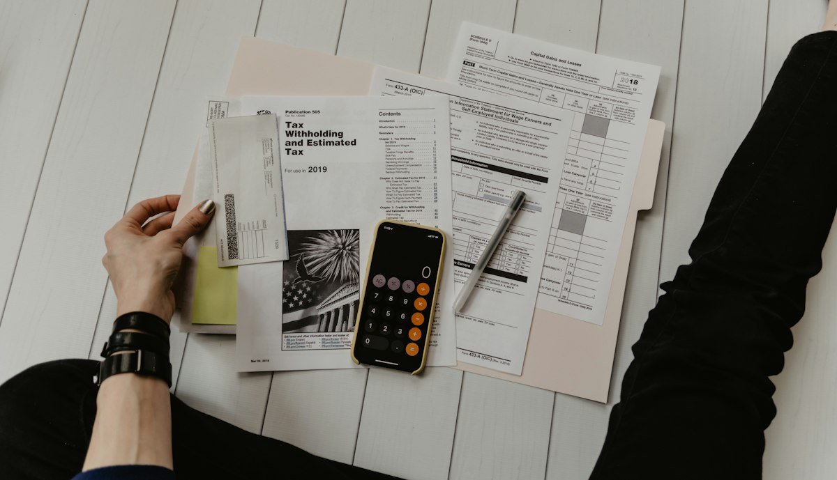 Calculator and income tax paperwork used to estimate small business tax liability.